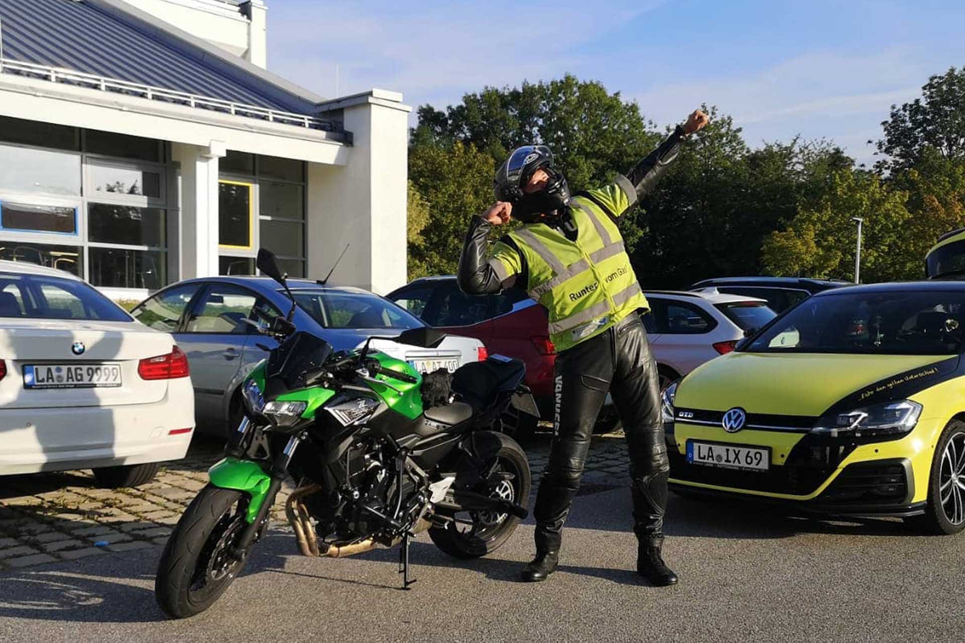 Fahrschüler posiert vor dem Landshuter TÜV Gelände mit Fahrschulauto und Fahrschulmotorrad